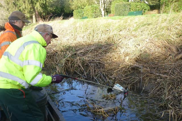 Members of Melton & Oakham Waterways Society remove a steel coinbox, believed to have been stolen from the Wilton Road toilet block, from the River Eye at Melton EMN-220214-120216001