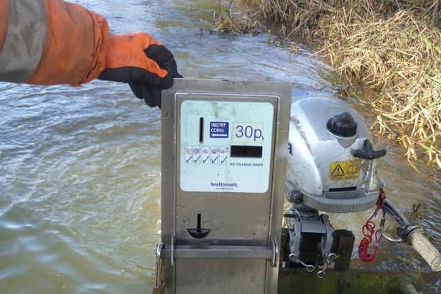 Members of Melton & Oakham Waterways Society remove a steel coinbox, believed to have been stolen from the Wilton Road toilet block, from the River Eye at Melton EMN-220214-120237001