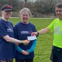 Andy Nicholls (SSRC treasurer and guide runner) handing over a cheque for £247 to Jane MacNaughton representing Vista, with Leigh Pick on the left.