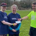 Andy Nicholls (SSRC treasurer and guide runner) handing over a cheque for £247 to Jane MacNaughton representing Vista, with Leigh Pick on the left.
