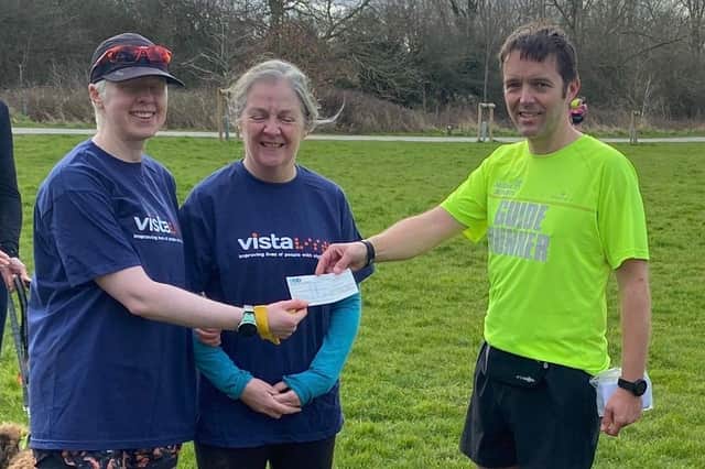 Andy Nicholls (SSRC treasurer and guide runner) handing over a cheque for £247 to Jane MacNaughton representing Vista, with Leigh Pick on the left.