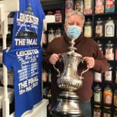 Jamie How, shows off the replica FA Cup trophy he is displaying in the window of his Melton shop, How Sweet EMN-211105-132331001