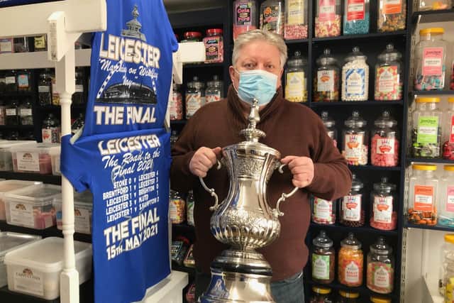 Jamie How, shows off the replica FA Cup trophy he is displaying in the window of his Melton shop, How Sweet EMN-211105-132331001