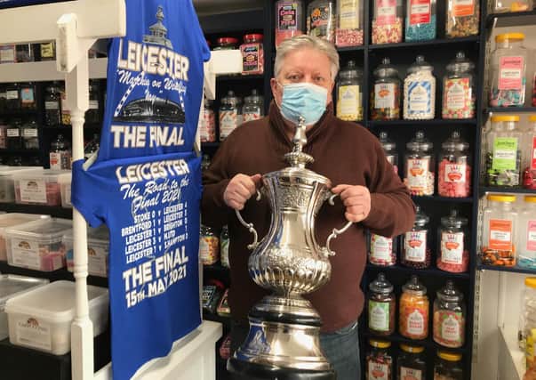 Jamie How, shows off the replica FA Cup trophy he is displaying in the window of his Melton shop, How Sweet EMN-211105-132331001