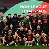 Thomson (seated far right) and teammates celebrate the Trophy win. Photo: Getty Images