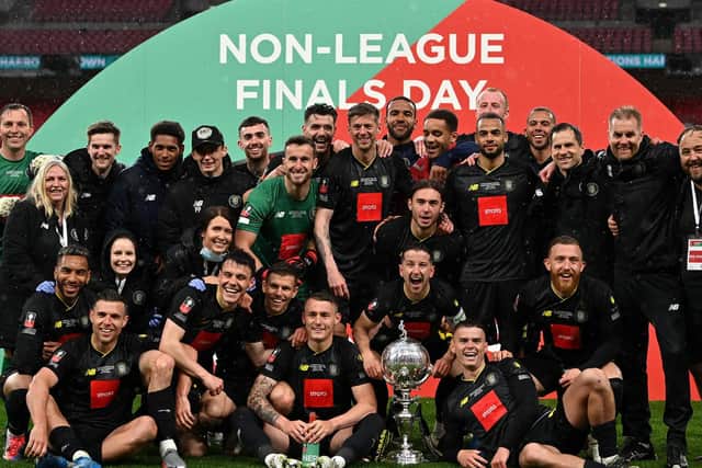 Thomson (seated far right) and teammates celebrate the Trophy win. Photo: Getty Images