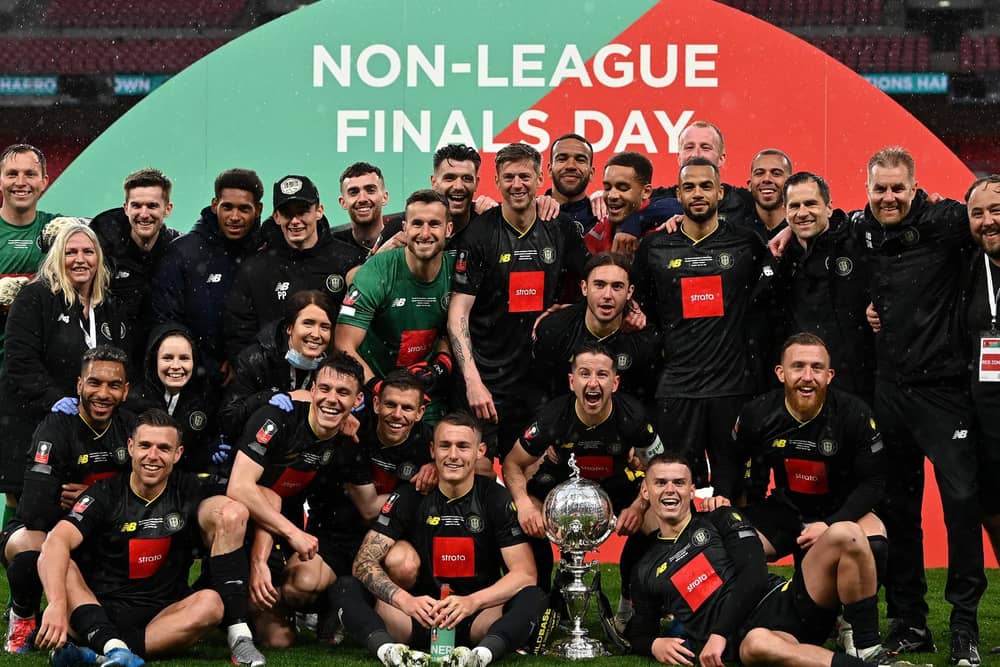 Thomson (seated far right) and teammates celebrate the Trophy win. Photo: Getty Images