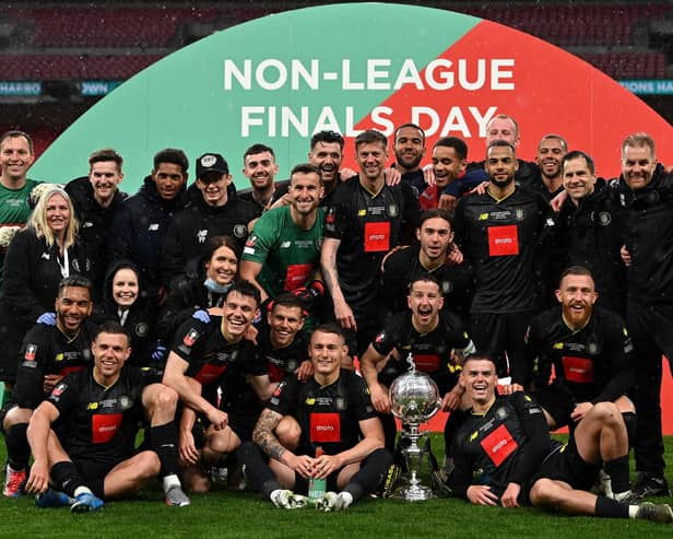 Thomson (seated far right) and teammates celebrate the Trophy win. Photo: Getty Images
