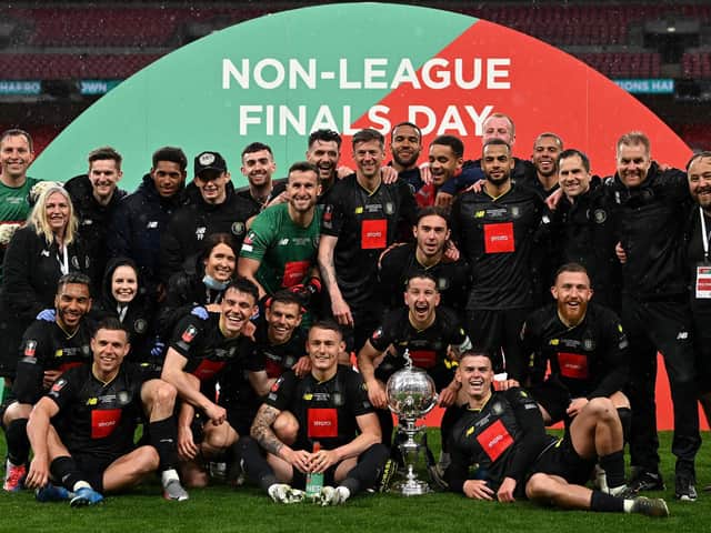 Thomson (seated far right) and teammates celebrate the Trophy win. Photo: Getty Images
