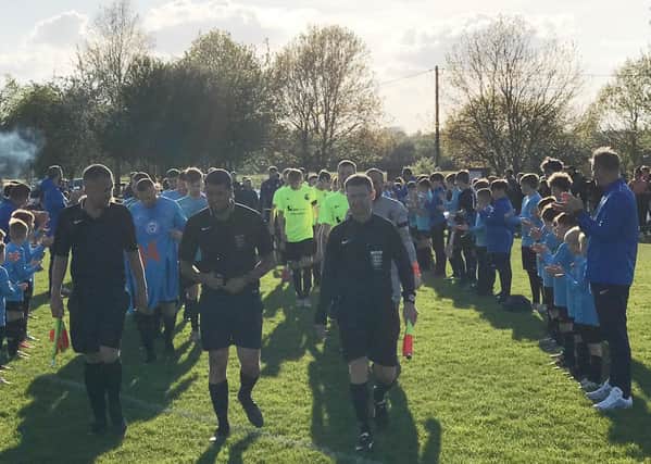 Youth players form a guard of honour at Asfordby FC as the teams take the field for last night's emotional testimonial match for Callum Payne EMN-210526-090538001