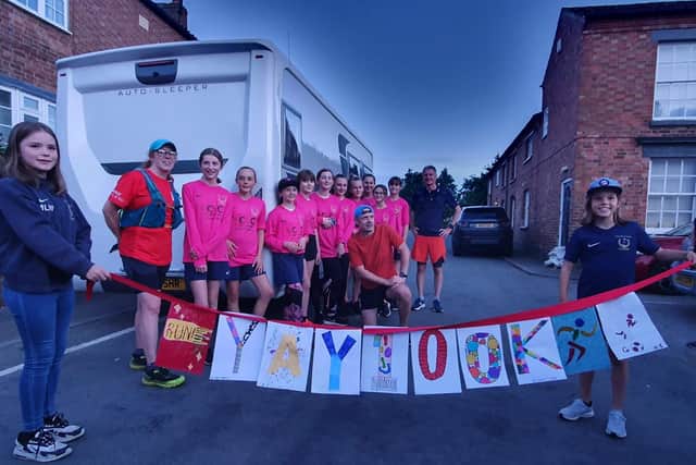 Luke Martino is congratulated by players from Asfordby Amateurs, Ladies Girls & Inclusive FC after completing his 100km run to raise money for a new 3G pitch for training EMN-210308-121254001