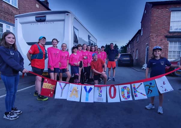 Luke Martino is congratulated by players from Asfordby Amateurs, Ladies Girls & Inclusive FC after completing his 100km run to raise money for a new 3G pitch for training EMN-210308-121254001