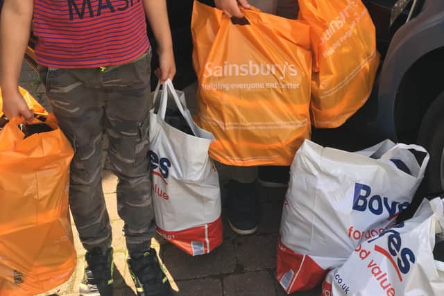 Helen Cliff's sons, Ethan and Lucas, help her with collecting provisions for the Melton refugees EMN-210914-171840001