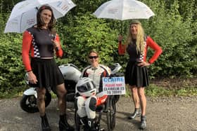 Claire Lomas wearing the racing leathers she will have on in Sunday's London Marathon with husband, Dan (left), and Stuart Hall, who will be running dressed as Grand Prix grid girls EMN-210929-131921001