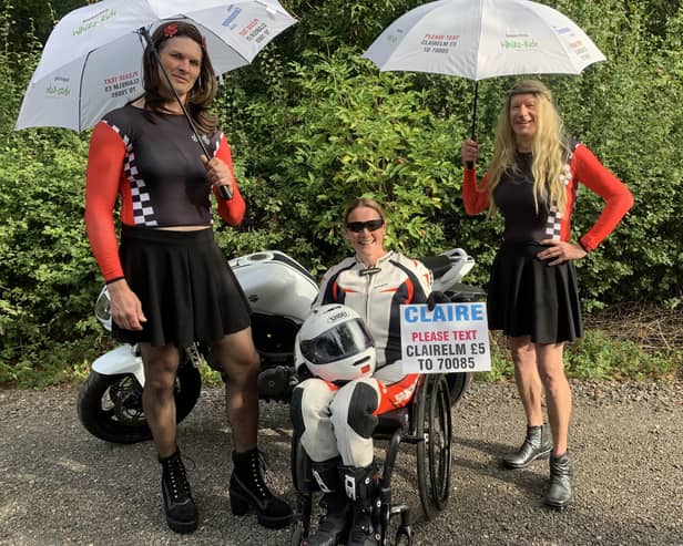 Claire Lomas wearing the racing leathers she will have on in Sunday's London Marathon with husband, Dan (left), and Stuart Hall, who will be running dressed as Grand Prix grid girls EMN-210929-131921001