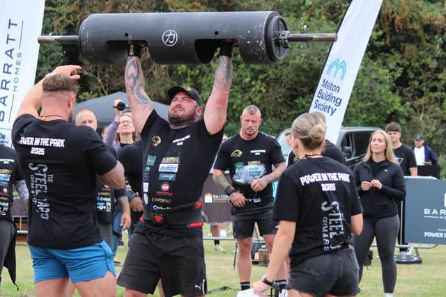 A competitor taking part in the log lift challenge at Power in the Park