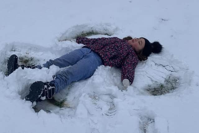 A little girl enjoys playing in the snow in Melton Country Park this morning