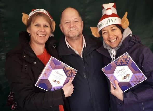 Christmas elves Shelagh Core (left) and Nikki Kirk offering their wrapping service to Melton shopper Alun Hodges back in December 2018