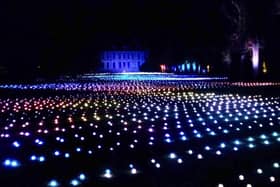 Sea Of Light - the dazzling Coldplay light show washes across the landscape in shimmering waves next to Belton House