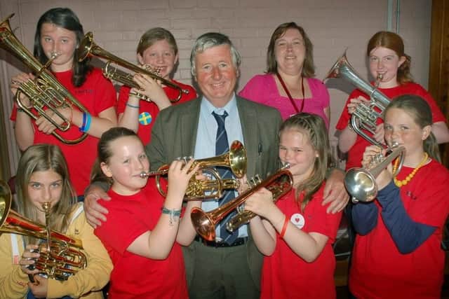 The late Fred Parker pictured with pupils at Brownlow Primary School when he retired from his full time teaching role in 2013