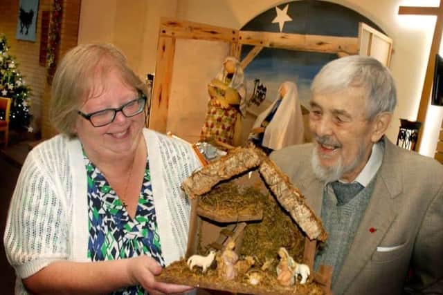Carol Scarborough and John Phillips admire Ray Jackson's wooden crib creation at the Crib Festival in 2018