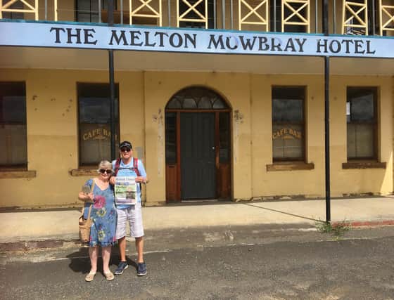 Carl and Barbara Watson holding a copy of the Melton Times outside The Melton Mowbray Hotel in Tasmania