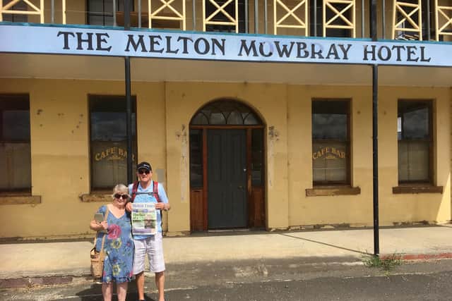 Carl and Barbara Watson holding a copy of the Melton Times outside The Melton Mowbray Hotel in Tasmania