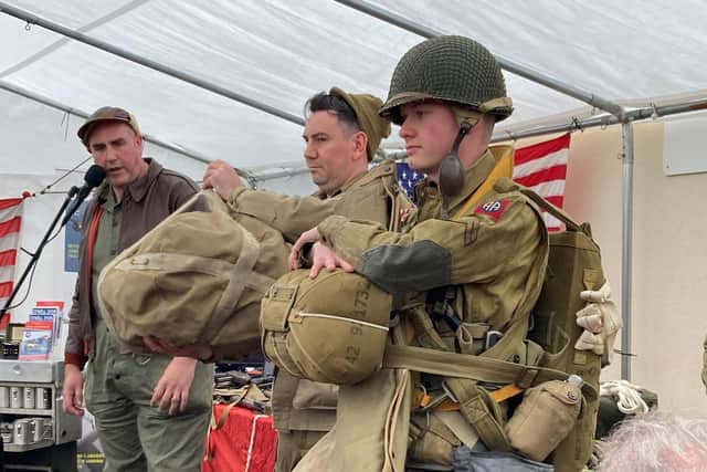 Reenactors demonstrate American paratroop combat kit worn on D-Day