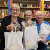 Storehouse manager, Siggy Atherton (left), with two of the volunteers holding food bags in the foodbank's shop