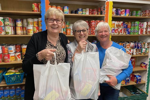 Storehouse manager, Siggy Atherton (left), with two of the volunteers holding food bags in the foodbank's shop