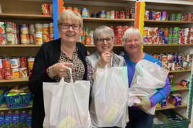 Storehouse manager, Siggy Atherton (left), with two of the volunteers holding food bags in the foodbank's shop