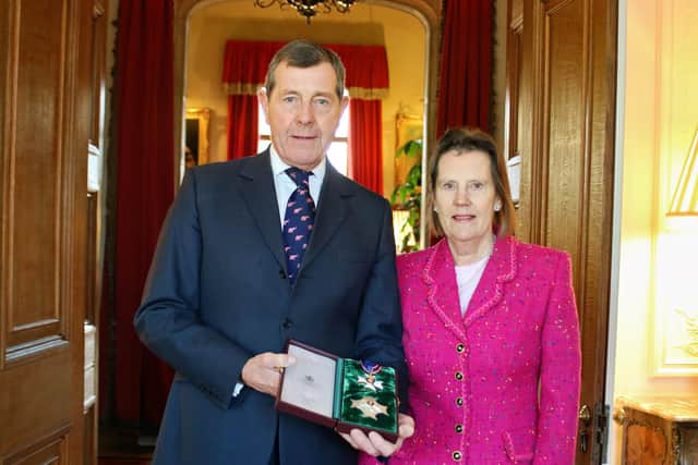 Charles Richards, with wife Serena, shows off his KVCO medal after the ceremony at Sandringham