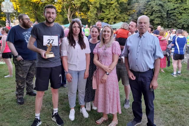 Lewis Atton wins his award for being 'youngest Whissendine runner' from Ed Richardson and the daughters of the late Chris Arnold at the presentations after the Whissendine 6ix road race