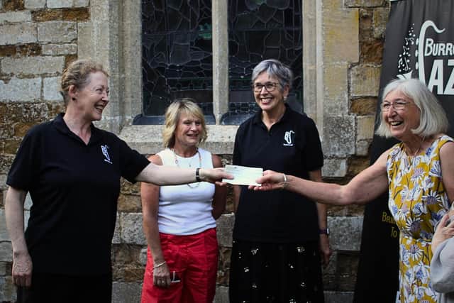 A cheque is presented by Gillian Geddes, artistic director of Burrough Jazz, to Sue Measey, PCC Treasurer, and other members at St Mary the Virgin, Burrough on the Hill