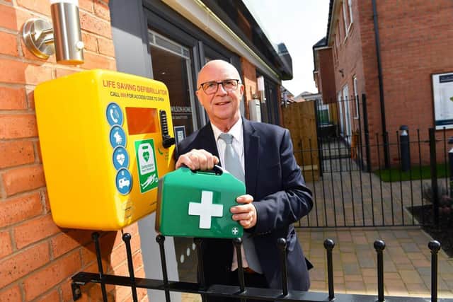 Sales Adviser, Ricky, with one of the new defibrillators installed by David Wilson Homes