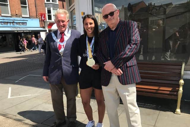 Iman Barlow next to the new golden bench with Mayor of Melton, Councillor Alan Hewson (left) and Councillor Robert Bindloss