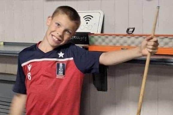 Izayah Fullerton with the cue and case he won in the pool marathon at Jackson's Lounge