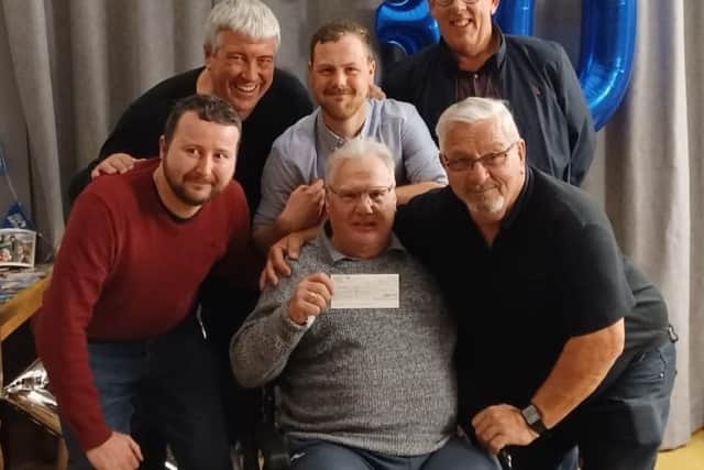 Long-serving former referee, Kevin Carter, shows off a cheque for £1,000 after being surprised with it by local referees