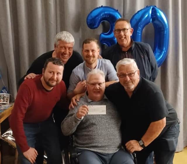 Long-serving former referee, Kevin Carter, shows off a cheque for £1,000 after being surprised with it by local referees