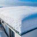 Heavy snow on a flat roof can cause structural damage.