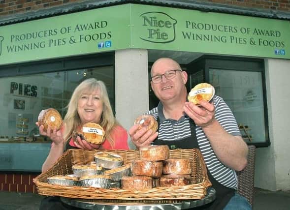 Phil and Kath Walmsley pictured outside the King Street shop they had in Melton for a short period