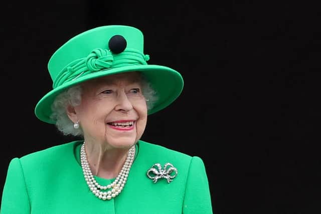 The late Queen Elizabeth II smiles to the crowd from Buckingham Palace balcony at the end of the Platinum Pageant in London on June 5, 2022 as part of Queen Elizabeth II's platinum jubilee celebrations. - The curtain comes down on four days of momentous nationwide celebrations to honour Queen Elizabeth II's historic Platinum Jubilee with a day-long pageant lauding the 96-year-old monarch's record seven decades on the throne. (Photo by Chris Jackson / POOL / AFP) (Photo by CHRIS JACKSON/POOL/AFP via Getty Images)