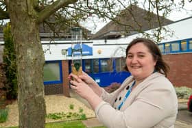 Samantha Harries, Headteacher at Swallowdale Primary School, hangs one of the bird feeders donated by Barratt Homes