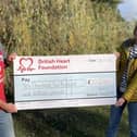 John Houghton presents a cheque to a representative of the British Heart Foundation following his marathon fundraising efforts