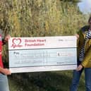 John Houghton presents a cheque to a representative of the British Heart Foundation following his marathon fundraising efforts