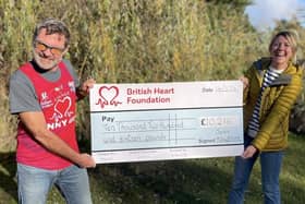 John Houghton presents a cheque to a representative of the British Heart Foundation following his marathon fundraising efforts
