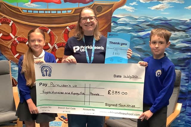Young Governors present a cheque to Katie Thomas (Parkinson's UK) from their fundraising