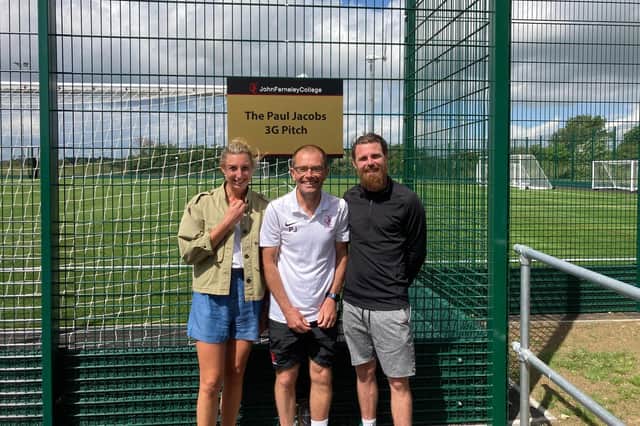 Long-serving John Ferneley College teacher Paul Jacobs (centre) at the new 3G pitch, which has been named after him, with head of school Natalie Teece and local football star, Paul Anderson