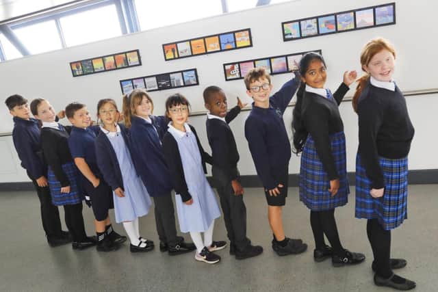 Children from a local school admire their own artwork on display at EMA