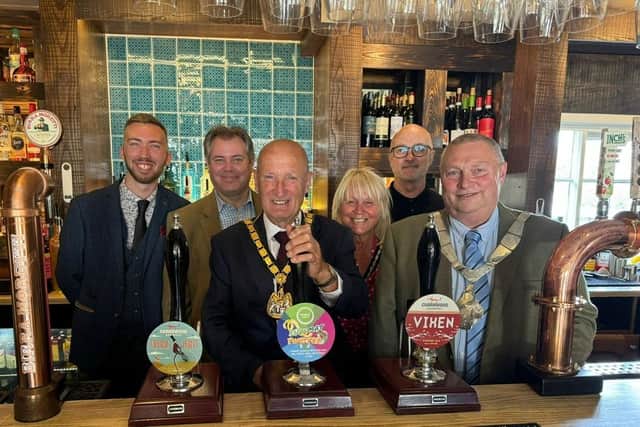 Councillor Joe Orson pulls a pint at The Crown, Old Dalby, flanked by general manager Rhys Dickerson, Edward Argar MP and Mayor of Melton Tim Webster